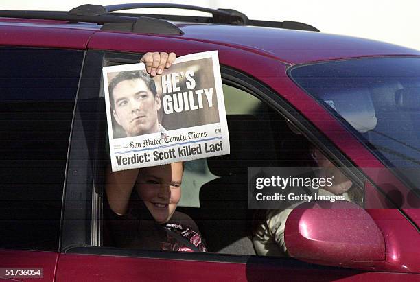 Passer-by holds up a special PM edition of the San Mateo County Times after the reading of the verdict that found Scott Peterson guilty of murder...