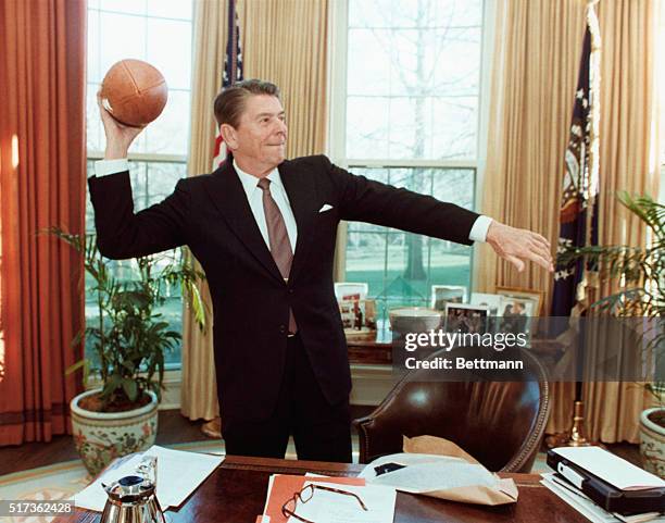 Washington, DC: With a familiar prop autographed by the 1982 University of Southern California football team, President Reagan duplicates his style...