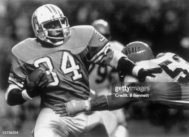 Running back Earl Campbell of the Houston Oilers pushes aside Cincinnati Bengal linebacker Bo Harris during a game on November 19, 1979 in Houston...