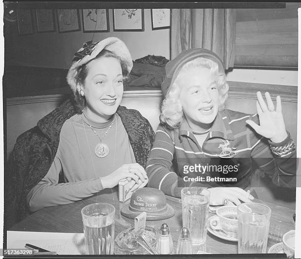 Hollywood, California: Hollywood Newsreel. A pair of Hollywood thrushes smile greetings at the Brown Derby. Dottie Lamour and Betty Hutton were...