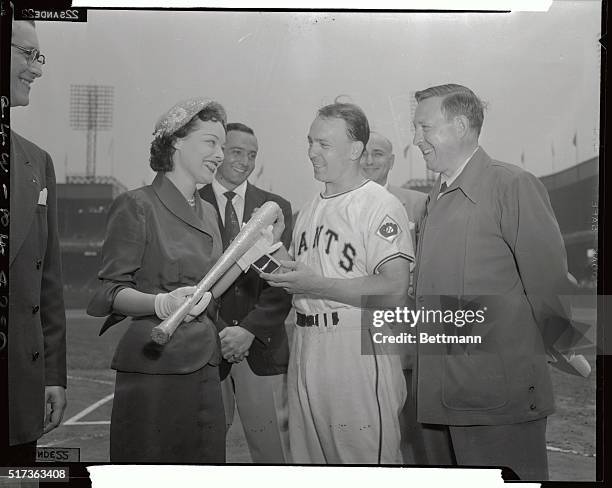 New York Giants second base man Ed Stanky is presented with a regulation size baseball bat studded with artificial diamonds, and a solid gold clasp...