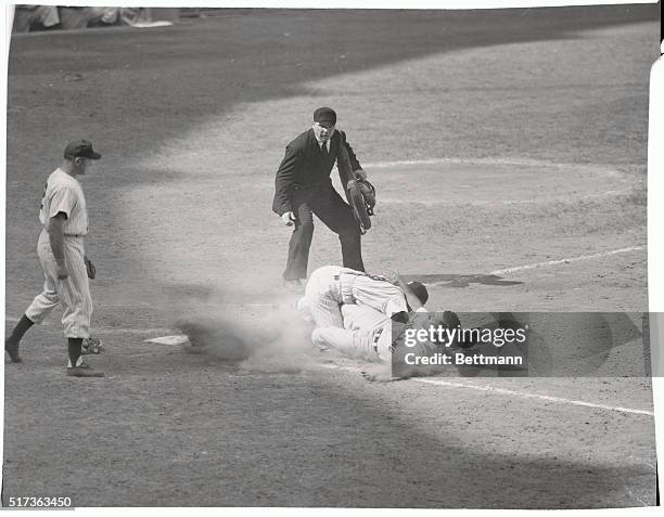 Taking the throw from Gil McDougald, Yank catcher Yogi Berra tags the sliding Bob Avila of Cleveland in the sixth inning of the July 26th game....