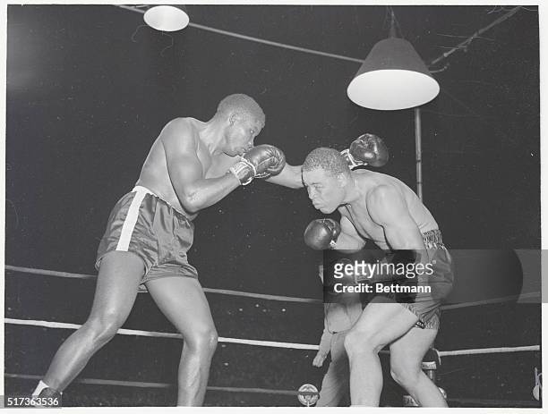 Baltimore, MD.: Joe Louis hands Jimmy Bivins a "right hook" during a close in flurry in the 7th round of last night's fight at Memorial Stadium in...