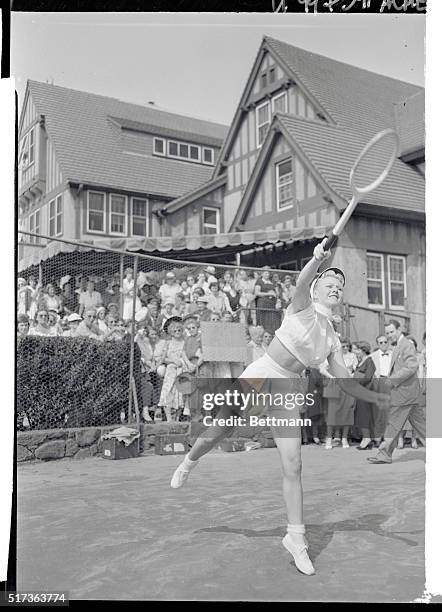 Film Actress Ginger Rogers warms up at the West Side Tennis Club as a crowd watches her first workout before participation in the mixed doubles...