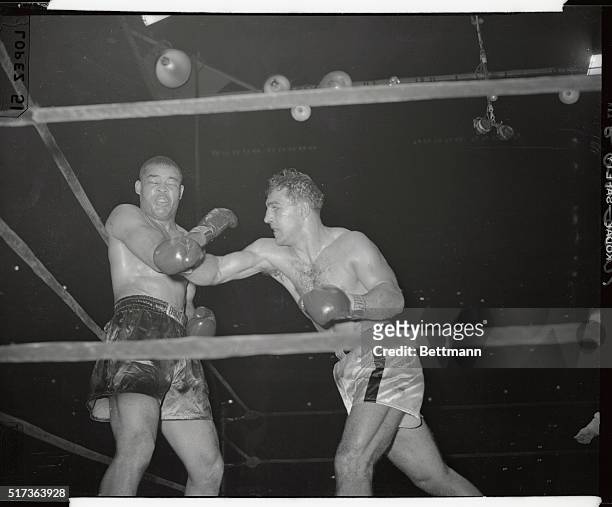 Rocky Marciano loops a powerhouse right to the chin of the ex-heavyweight champ, Joe Louis, in their scheduled ten-round bout at Madison Square...