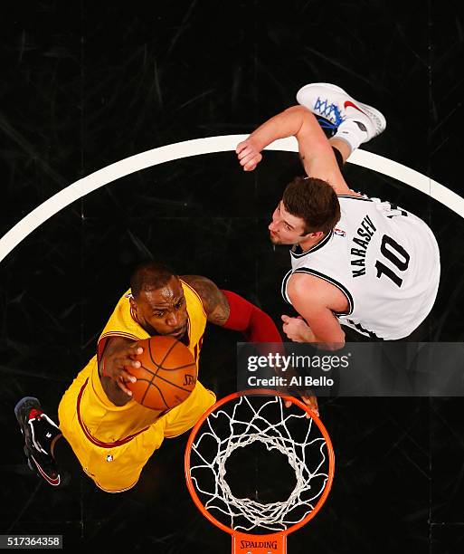 LeBron James of the Cleveland Cavaliers dunks against Sergey Karasev of the Brooklyn Nets during their game at the Barclays Center on March 24, 2016...