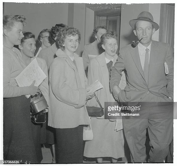Female autograph fans are ignored by singer Bing Crosby as he arrives at Los Angeles Superior Court to appear in connection with a $1 000 damage suit...