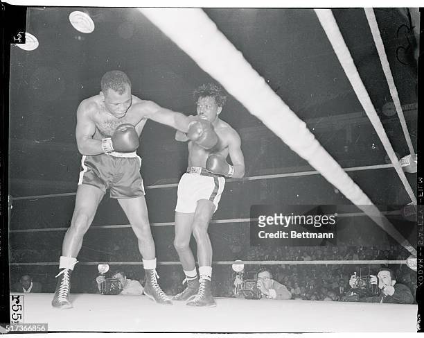 Former middleweight champion Sugar Ray Robinson wards off a left thrown by Ralph "Tiger" Jones during their ten-round bout at Chicago Stadium January...