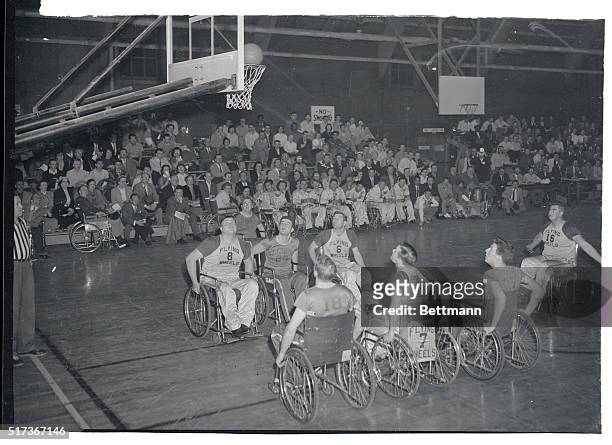 Arthur Eaks of the "Flying Wheels" basketball squad, makes good on free throw during game with group of paralyzed students from Illinois University's...