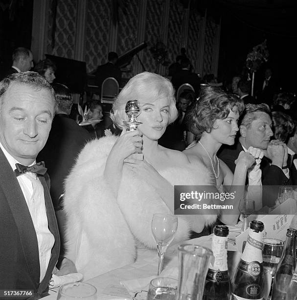 Marilyn Monroe eyes her "Golden Globe" award with pride after she won the award presented by members of the Hollywood Foreign Press Association for...