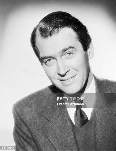 James Stewart, , film actor smiling for the camera in a head and shoulders publicity photo.