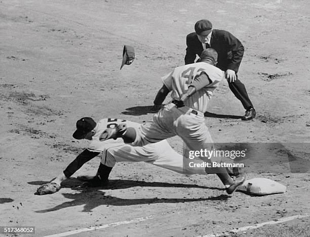 Jackie Robinson of the Dodgers is minus his cap as he reaches for first base too late in first inning action of today's season opener against the New...