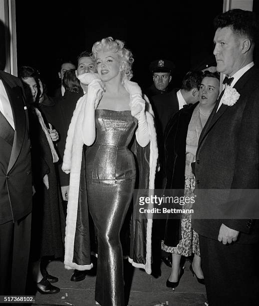 Actress Marilyn Monroe steals the show again as she arrives wearing a slinky evening gown for the New York opening of Tennessee William's New Play,...