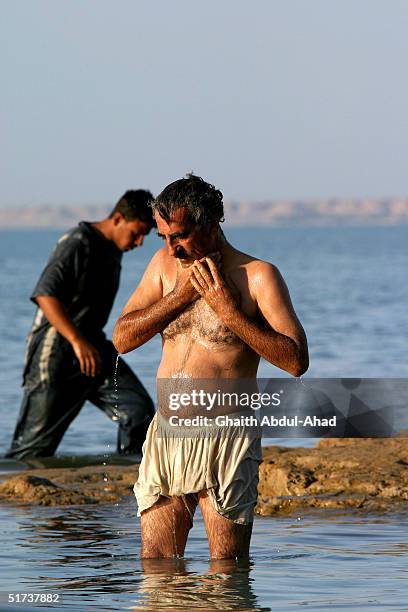 Refugees from Fallujah take a bath in a lake November 13, 2004 in the Habaniya camp outside of Fallujah, Iraq. Hundreds of refuges who fled the...