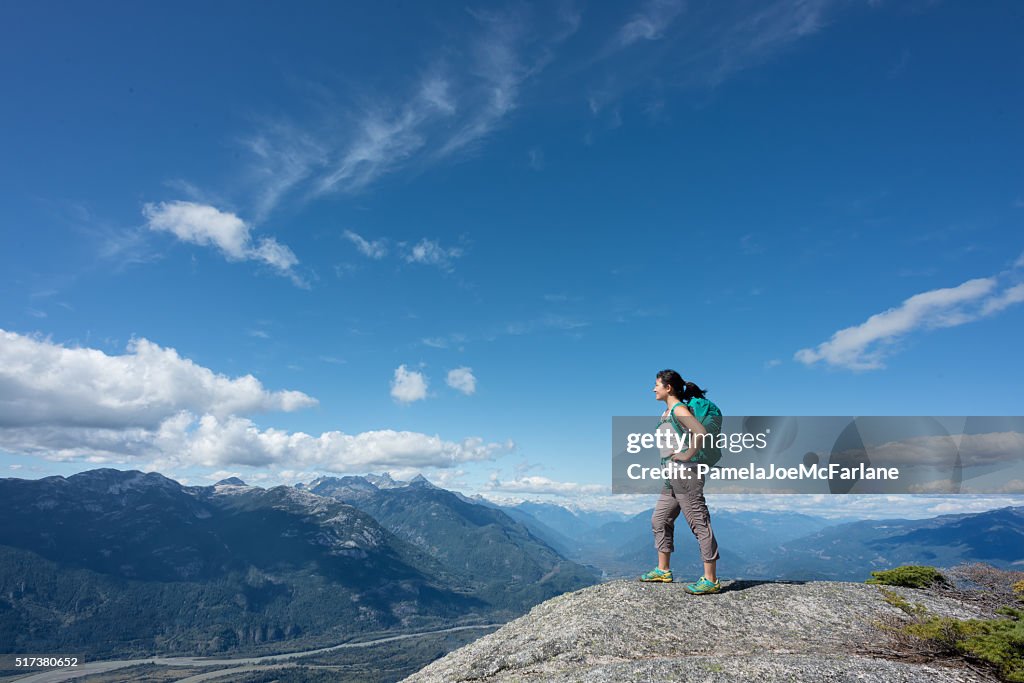 Solo Woman Hiker with Backpack Enjoying View from Mountain Summit