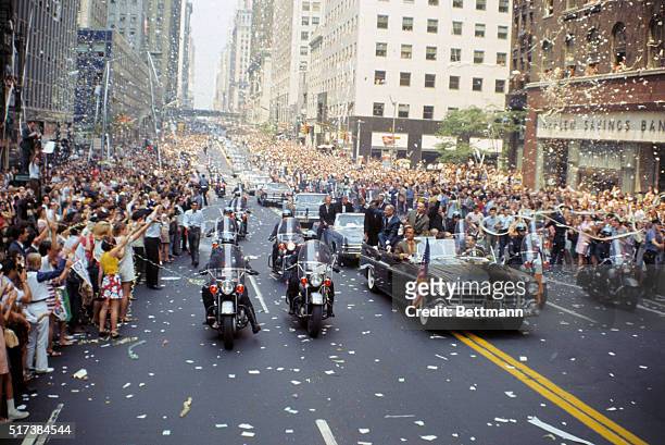 Apollo 11 astronauts, left to right: Buzz Aldrin, Michael Collins, and Neil Armstrong wave to crowds on 42nd Street in open car while on the way to...