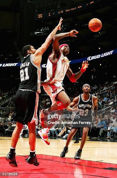 Al Harrington of the Atlanta Hawks loses the ball against Tim Duncan of the San Antonio Spurs during a game November 13, 2004 at Phillips Arena in...