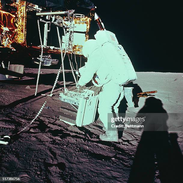 Space Center, Houston: An Apollo 12 astronaut, having detached ALSEP from lunar module, prepares to deploy the scientific experiments on lunar...