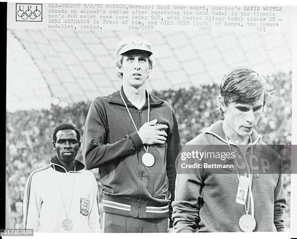 Hand over heart, America;s David Wottle stands on winner's podium after receiving the Gold Medal in the Olympic men's 800 meter race here today 9/2,...