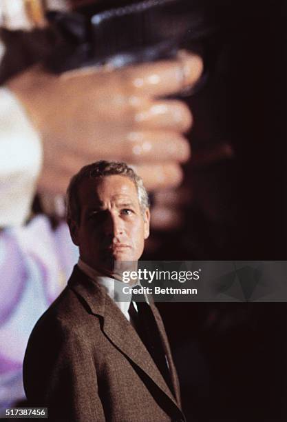 Paul Newman, repeating his characterization of Harper, pauses under a giant hand and gun in his search for the killer in the action thriller The...