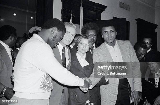 Trenton, N.J.: World heavyweight champ Muhammad Ali and former champ Joe Frazier shake hands after they and actress Ellen Burstyn met with New Jersey...