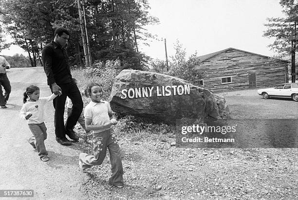 World heavyweight champ Muhammad Ali holds the hands of his twin daughters Jamalliah and Rahshoda as his daughter Miriam runs alongside at his...