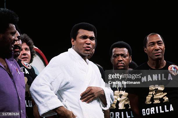 Manila, Philippines: Muhammad Ali at the weigh-in for the Ali Versus Frazier fight surrounded by his entourage of helpers who wear t-shirts...