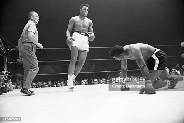 Heavyweight champion Muhammad Ali dances away from the contender Floyd Patterson , after the former champion slipped and fell to his knees during the...