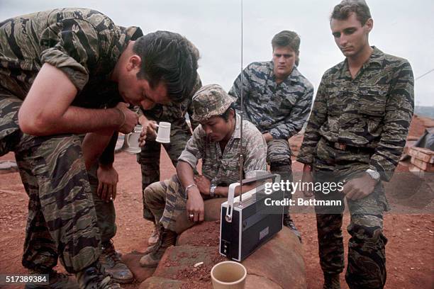 Duc Lap, South Vietnam- Members of the Special Forces- CIDG and U. S. Artillery battery gather around portable radios to lsiten to President Nixon's...