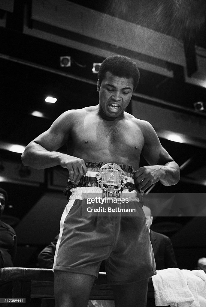 Muhammad Ali Admiring His Championship Title Belt