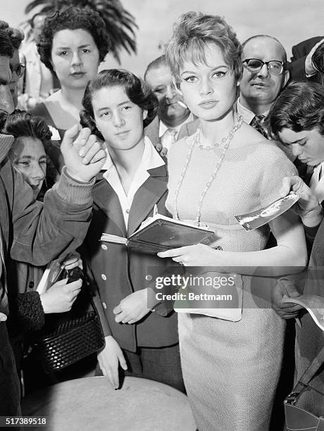 Cannes, France-Doe-eyed, French, film star Brigitte Bardot pauses in her autograph-signing to answer a fan's query. The wind-blown lovely is here to...