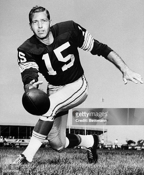 Bart Starr, quarterback for the Green Bay Packers, is shown throwing the ball while running.