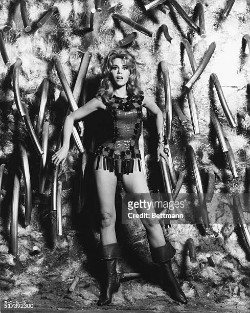 Publicity photo for the 1968 film "Barbarella," with Jane Fonda standing in front of a tubular morass wearing a body suit with plastic fringe around...