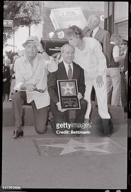 Actor Tim Conway gets a kiss on the head from Carol Burnett and an elbow in the shoulder from actor Harvey Korman after receiving his star on...