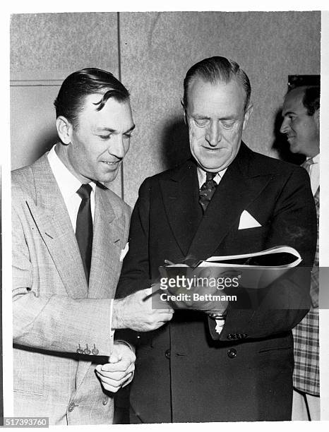 Ben Hogan , non-playing captain of the U.S. Ryder Cup golf team, and his British counterpart, Reg Whitcombe, sign autographs for each other at a...
