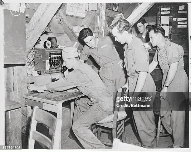 Scene in one of the shacks of the security patrol that guards Hawaii from another "Pearl Harbor" as pilots cluster around the man on communications...