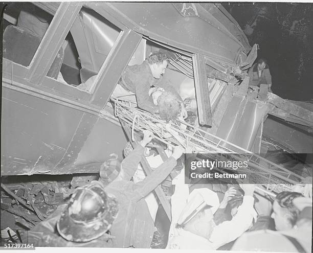 Woodbridge, New Jersey: Helping Hands. Ignoring the body of the dead man braced in the window, a rescue worker lifts an unconscious woman through the...