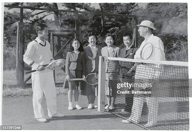 At a family get-together, Emperor Hirohito plays the sportsman and takes on his son, Crown Prince Akihito , in a spot of tennis. Looking on in...