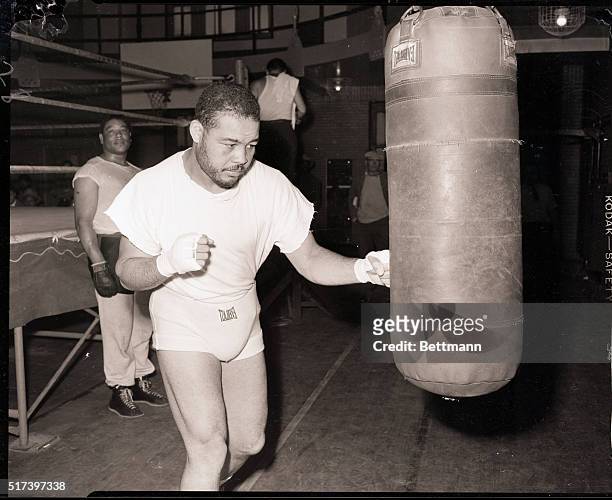 Chicago, IL- Ex-heavyweight king Joe Louis, sporting a month's growth of whiskers, punches the heavy bag in a Chicago gymnasium in preparation for...