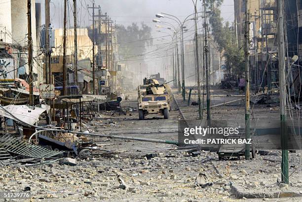 Marines from the 3/5 Lima company ride in their Humvees along the main high street of the restive city of Fallujah 14 November 2004, 50 kms west of...