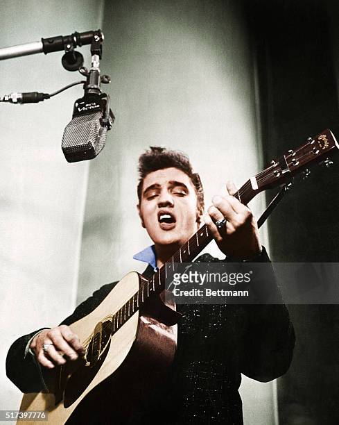 Close up of Elvis Presley playing guitar.