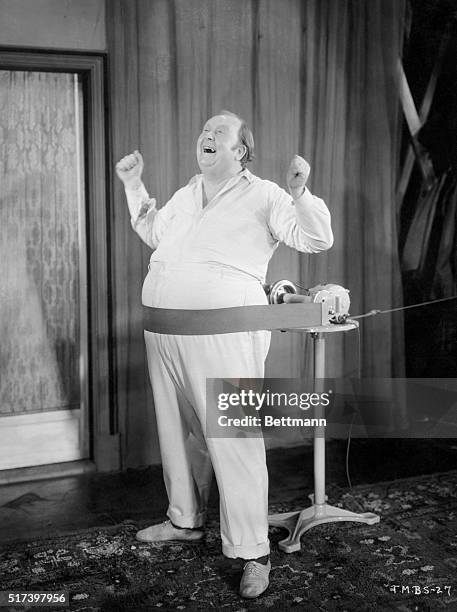 "The musical beauty shop": A portly gentleman sings as his belly is mechanically massaged. Undated B/W photograph.