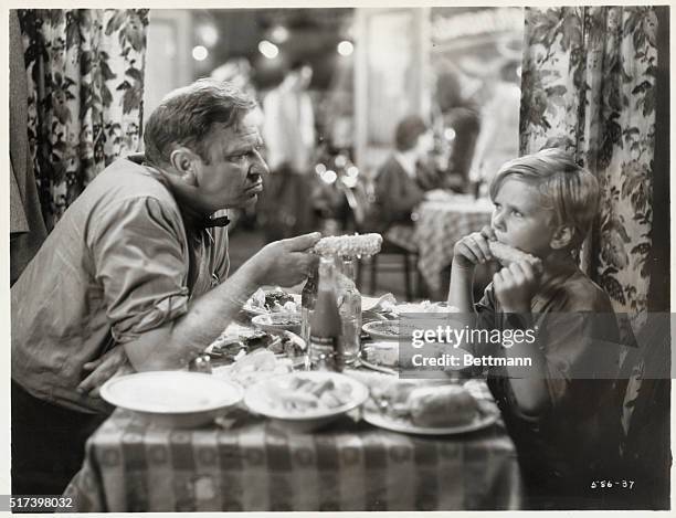 Wallace Beery , and a young Jackie Cooper eat corn-on-the-cob in "The Champ" . Movie still. BPA2# 1240