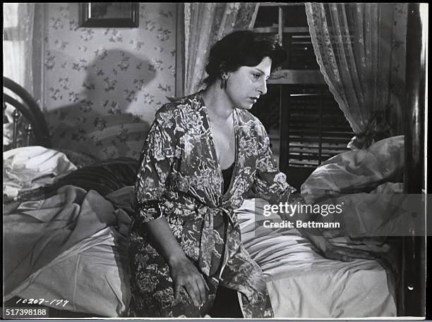 Anna Magnani as Serafina Delle Rose sits on her bed, looking distressed, in a movie still from "The Rose Tattoo," directed by Daniel Mann.