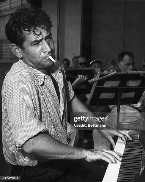 Leonard Bernstein American Conductor and composer smoking a cigarette at the piano in his younger days.