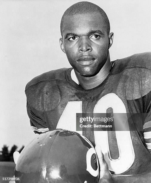 Picture shows Chicago Bears pro-football halfback, Gale Sayers, posing in his uniform holding his helmet. Undated photo.