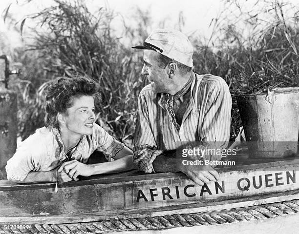 Humphrey Bogart as Charlie Allnut and Katharine Hepburn as Rose Sayer in the 1951 film The African Queen and aboard the boat of the same name.