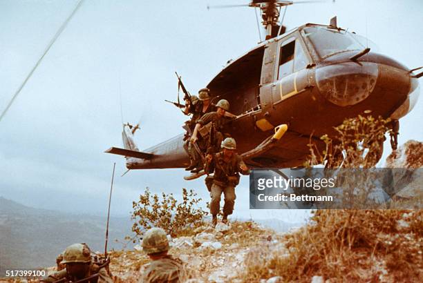 Group of infantrymen from the 1st Cavalry Division jump from a Bell UH-1 Iroquois, also known as a "Huey", as they begin a reconnaissance mission in...