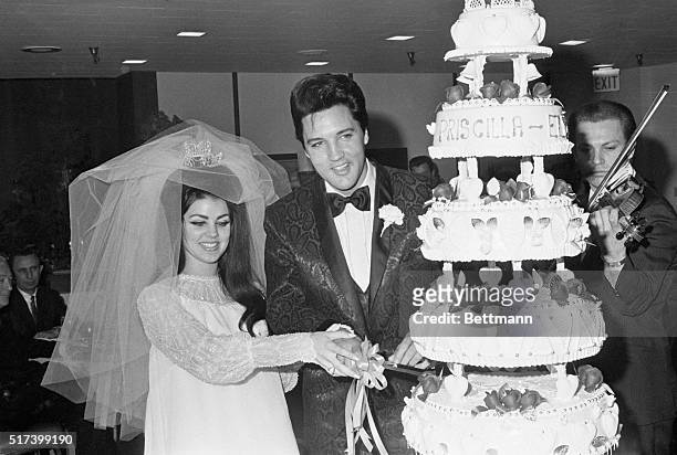Las Vegas, NV- Singer Elvis Presley and Priscilla Ann Beaulieu cut the cake at the Las Vegas reception following their wedding, 5/1. Presley met his...