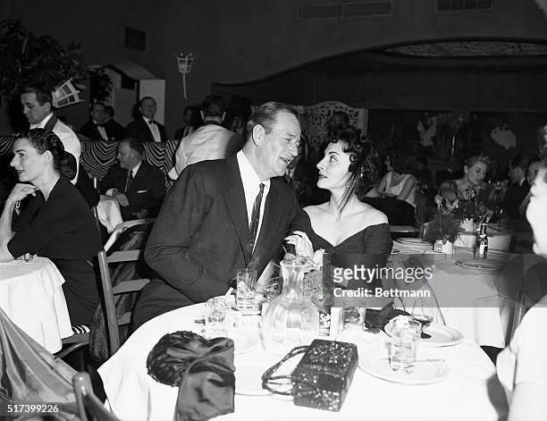 New York, NY: Actor John Wayne and his wife Pilar dine at the El Morocco Club.